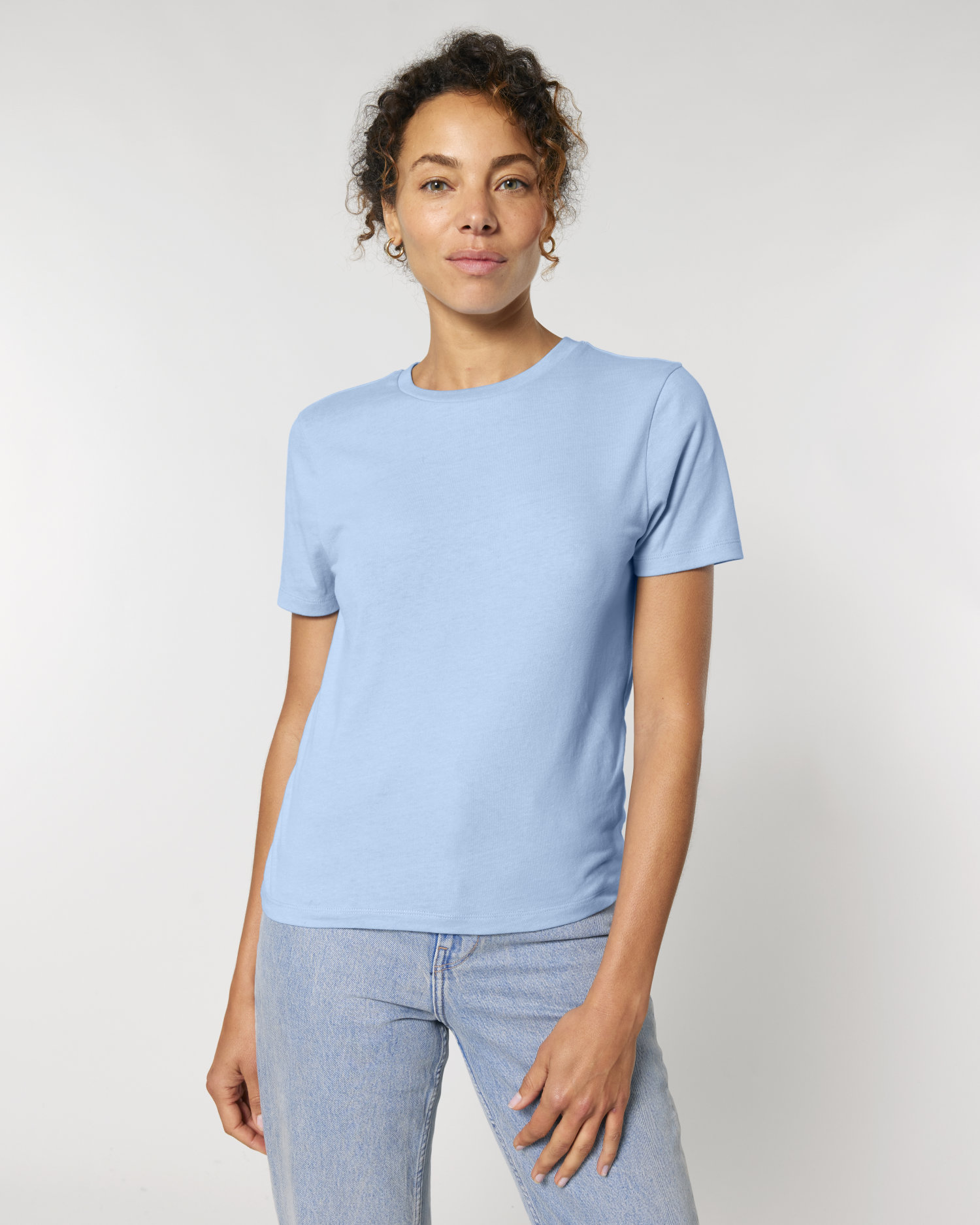 Frau im hellblauen, taillierten Damen-T-Shirt Stella Ella von Stanley/Stella